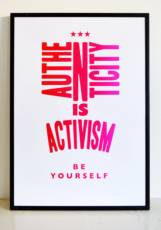 framed poster that says authenticity is activism in pink letters.
